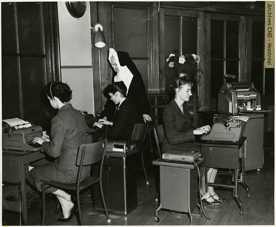 Sister Lucille Goodman supervises the work of the students in the dictaphone lab of Collège de secrétariat Notre-Dame Secretarial College